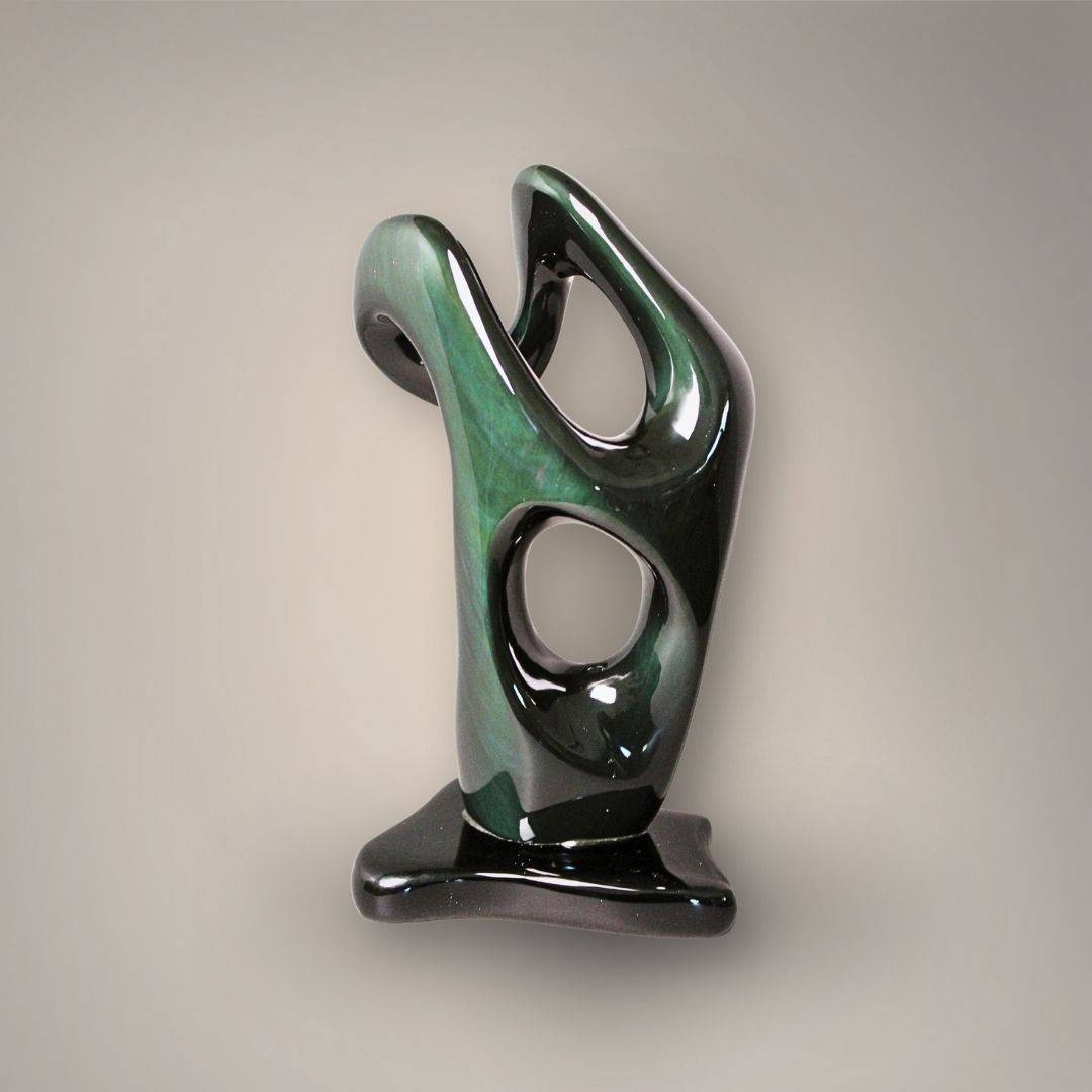 Front view of Mexican Velvet Rainbow Obsidian figural sculpture with flowing openwork design, green flash, and polished black base.