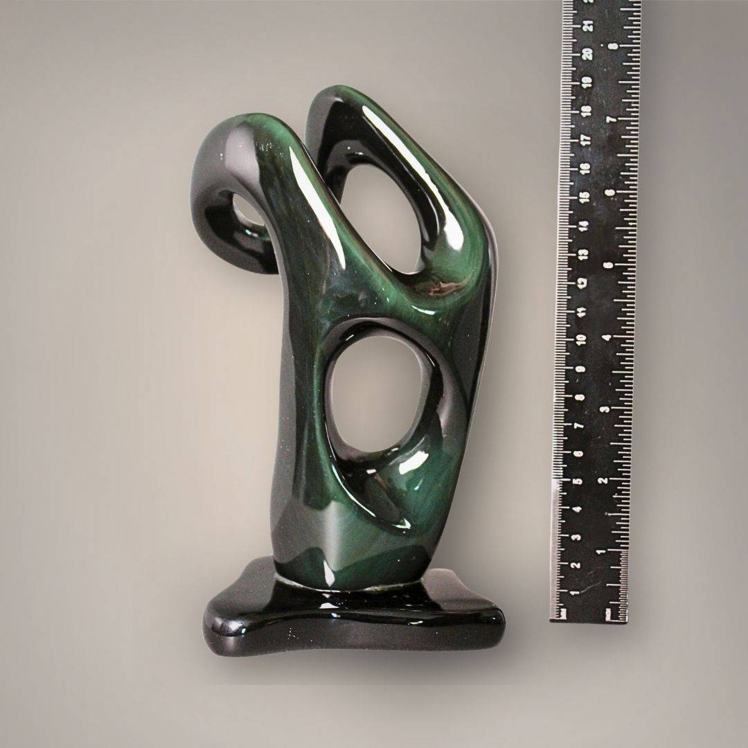 Front view of seven-inch Velvet Rainbow Obsidian sculpture beside a ruler showing its height and openwork carving.