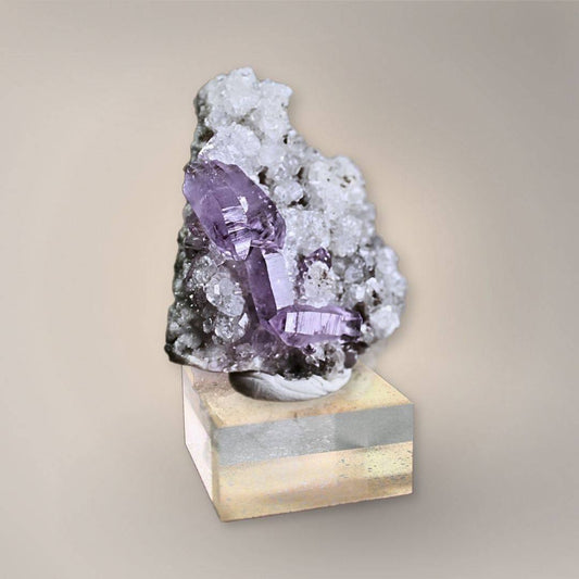 Front view of the Veracruz Amethyst cluster featuring four deeply saturated, double terminated crystals on a white quartz druzy base.