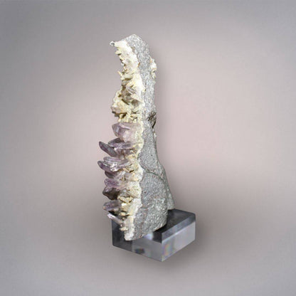 Side profile of Mexico Veracruz Amethyst showing slender projecting quartz crystals along the edge of the volcanic matrix on the included stand.