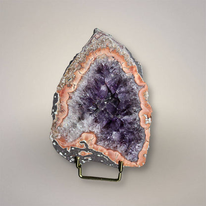 Waldhambach Germany agate specimen with deep purple amethyst core, rose-orange banding, and polished face on display stand.
