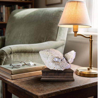 Quartz with scheelite and fluorite specimen displayed on a dark mineral stand in an interior setting.